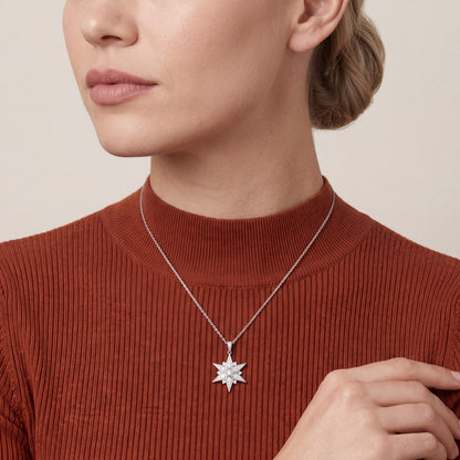 Woman in a rust mock-neck knit wearing the natural diamond pavé starburst pendant necklace in 14K white gold