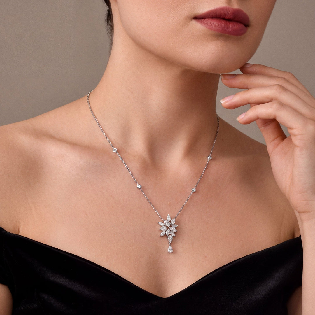 Natural diamond pear and marquise cluster drop necklace in 18K white gold, worn with a black velvet off-shoulder gown