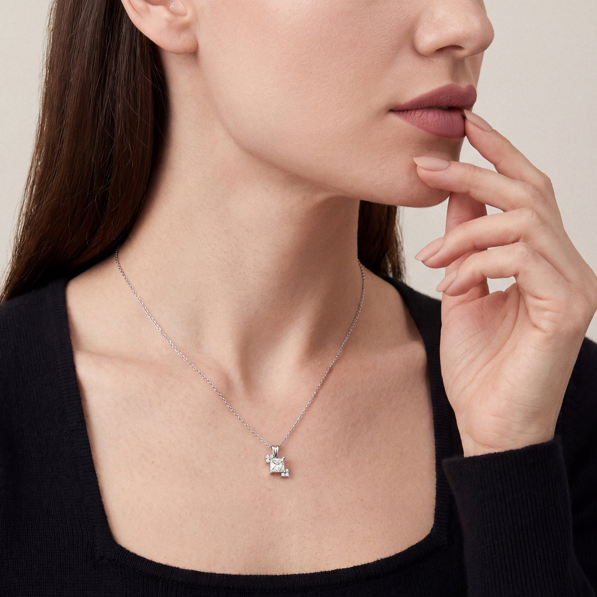 Woman in a black square-neck cashmere top wearing a 0.53 ct princess-cut natural diamond solitaire pendant in 14K white gold