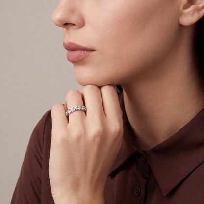 Woman in a chocolate-brown silk shirt wearing a 0.65 ct natural diamond half eternity ring in 14K white gold on the ring finger, hand under the chin