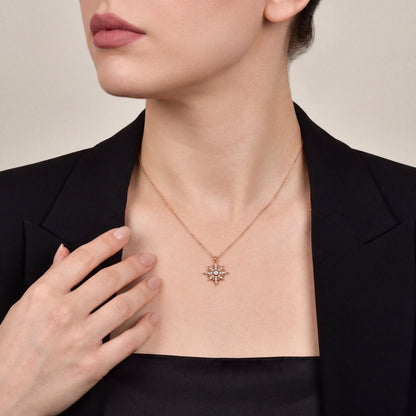 Woman in a black blazer wearing the natural diamond starburst pendant necklace in 14K rose gold
