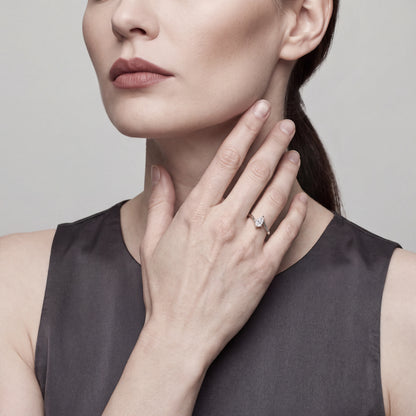 Model in a charcoal satin top wearing a 0.72 ct pear-cut natural diamond solitaire ring in 14K white gold