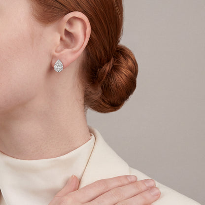 Woman in a cream wool blazer and high mock neck wearing a pear-shaped natural diamond cluster halo stud earring in 14K white gold
