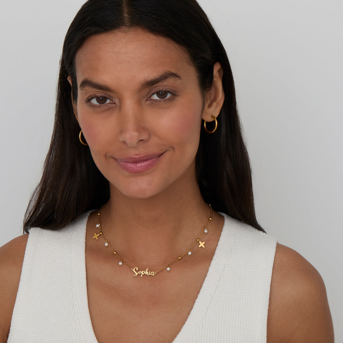 Pearl Name Necklace with Gold Petal Charms styled with gold hoops — personalized everyday necklace.