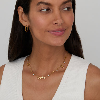 Woman wearing the Pearl Name Necklace with Gold Petal Charms in 18K gold-plated steel.