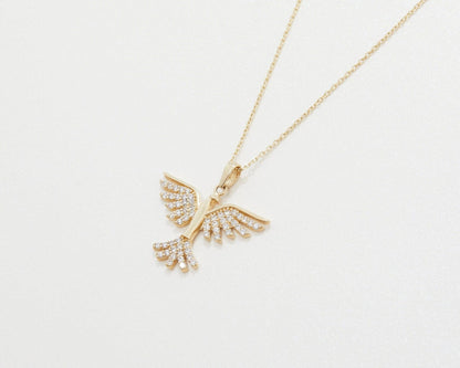 The 14K solid gold phoenix pendant on its chain, lying at an angle on a white background.