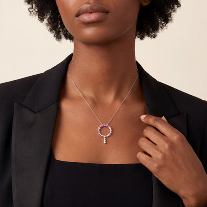 Woman in a black tuxedo jacket wearing the pink gemstone and natural diamond open circle drop necklace in 14K white gold