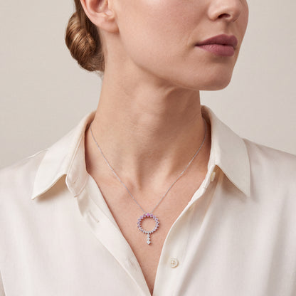 Woman in an ivory silk shirt wearing the pink gemstone and natural diamond open circle drop necklace in 14K white gold