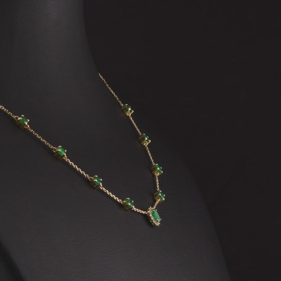 360 degree video of the emerald and natural diamond halo station necklace in 14K yellow gold