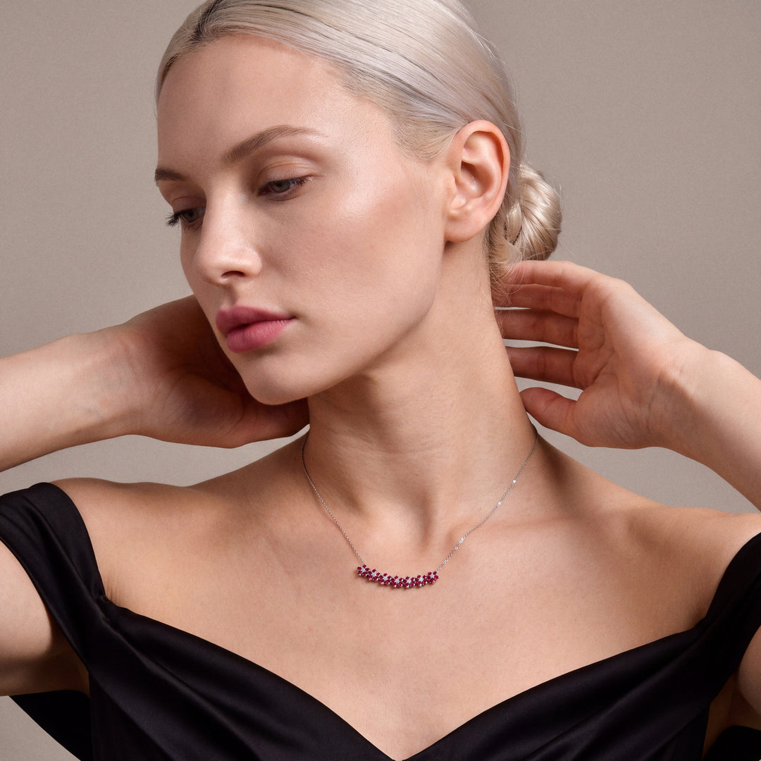 Ruby and natural diamond flower bar necklace in 14K white gold, worn with a black satin off-shoulder gown
