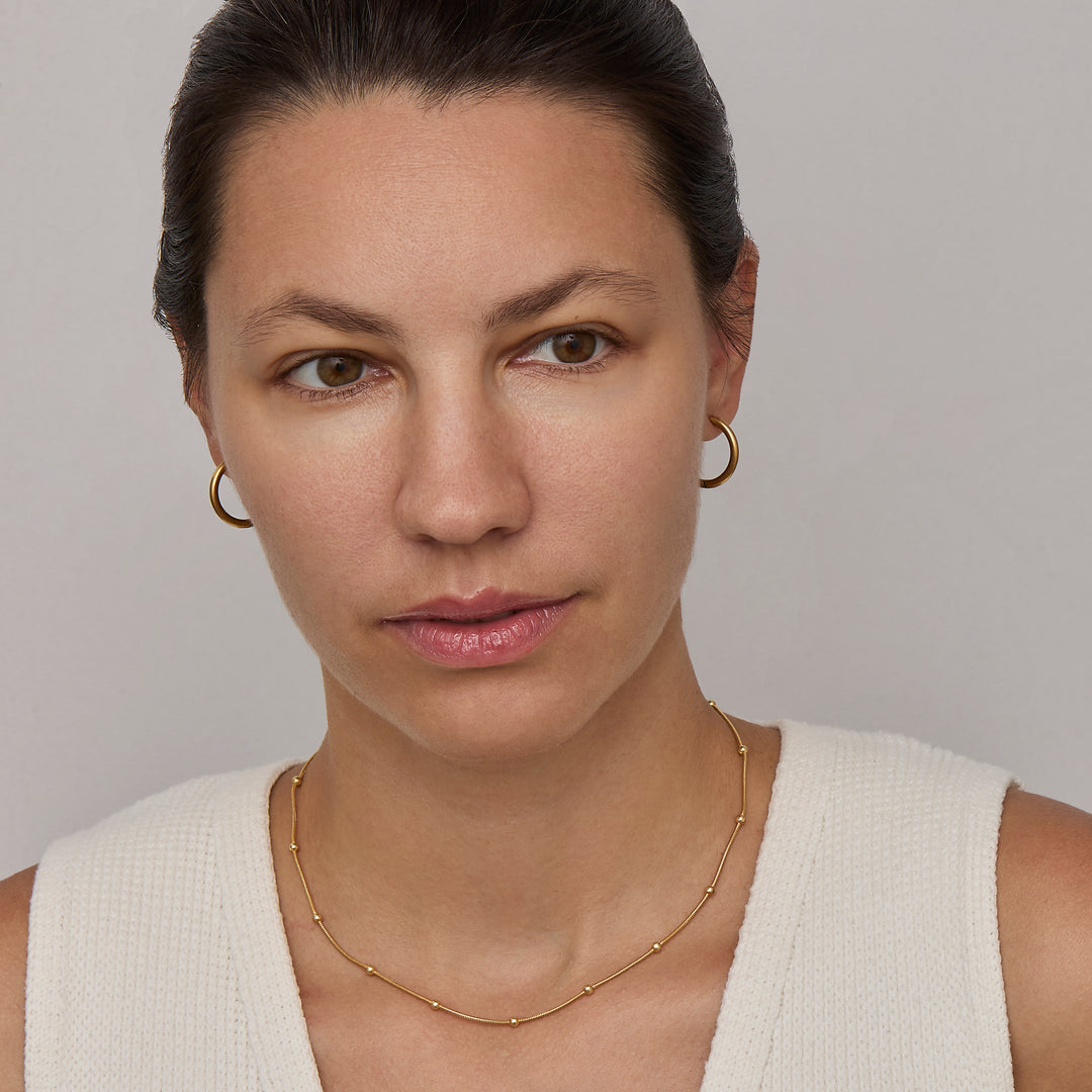 Gold beaded satellite chain necklace at collarbone length
