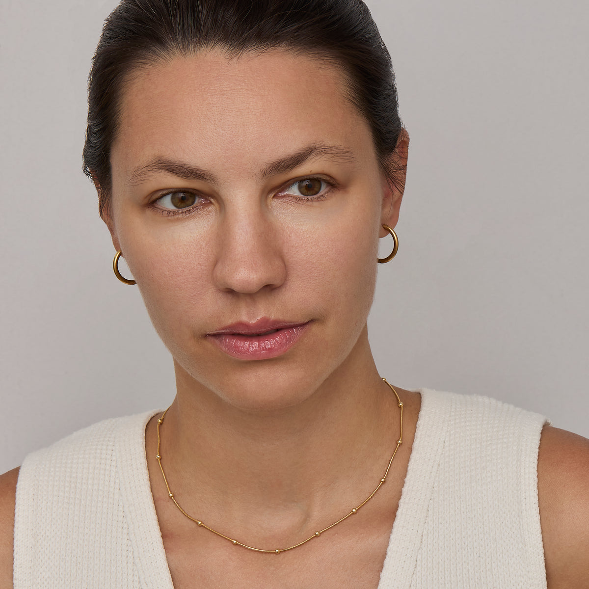 Gold beaded satellite chain necklace at collarbone length
