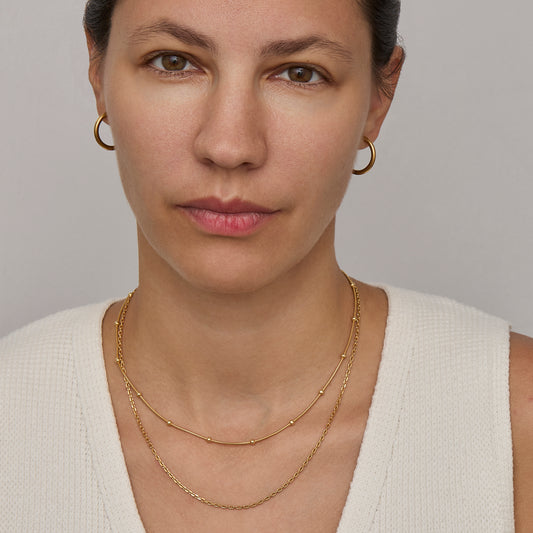 Gold satellite chain necklace worn on the neck
