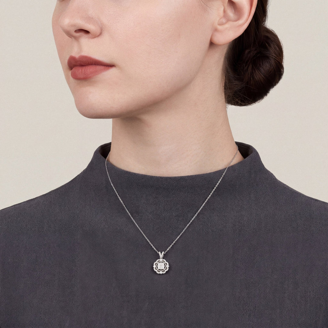 Woman in a charcoal crepe funnel-neck top wearing a 0.47 ct tw natural diamond scalloped halo pendant necklace in 14K white gold