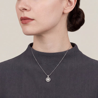 Woman in a charcoal crepe funnel-neck top wearing a 0.47 ct tw natural diamond scalloped halo pendant necklace in 14K white gold