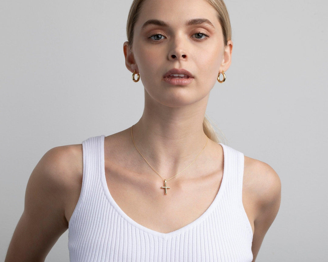 The Small Cross Necklace styled in 18K Gold Vermeil — elegant everyday jewelry. Hypoallergenic, no green marks.