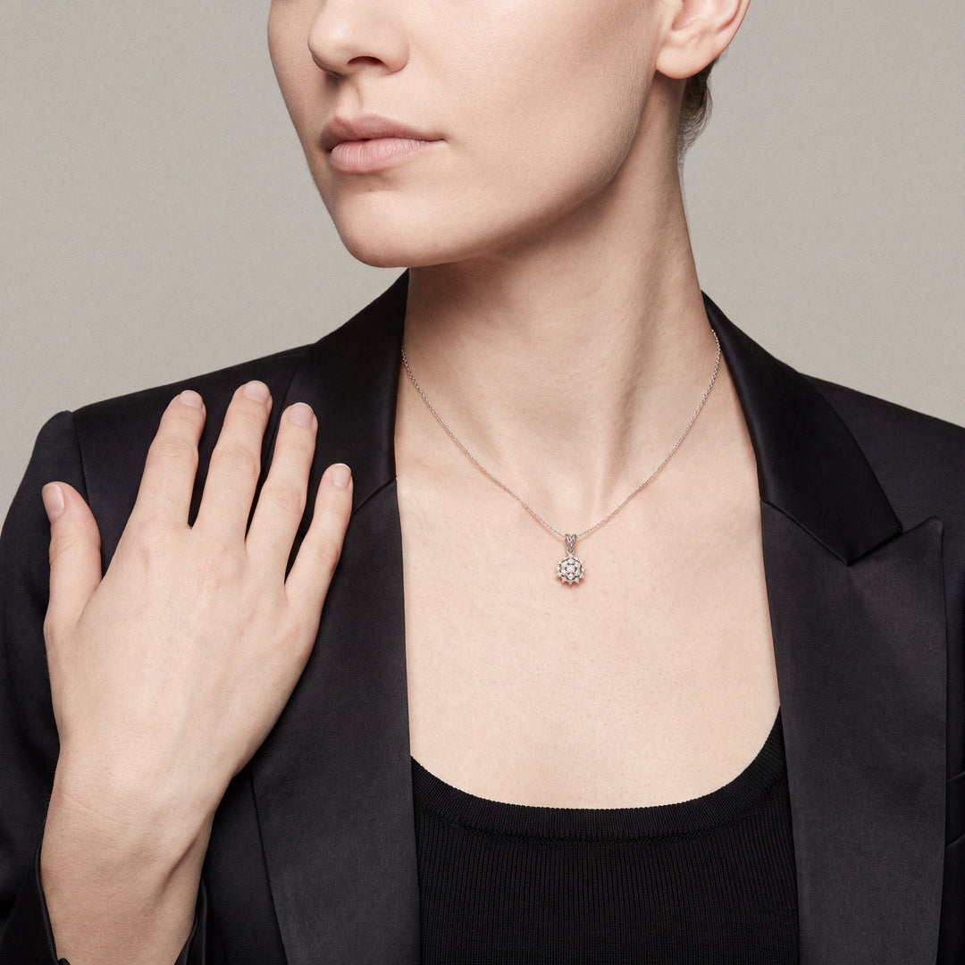 Woman in a black satin tuxedo blazer, hand resting at her shoulder, wearing the starburst natural diamond cluster pendant necklace in 14K solid white gold