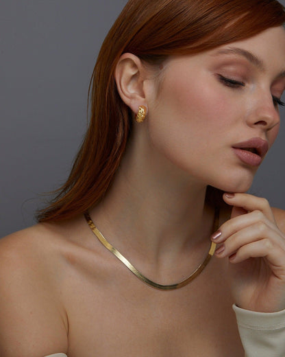Macro detail of the Textured Hinged Huggie Hoop Earrings showcasing craftsmanship in 18K Gold Vermeil. No green marks.