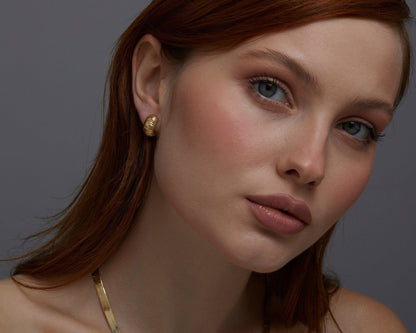Macro detail of the Textured Huggie Earrings showcasing craftsmanship in 18K Gold Vermeil. No green marks, handmade.