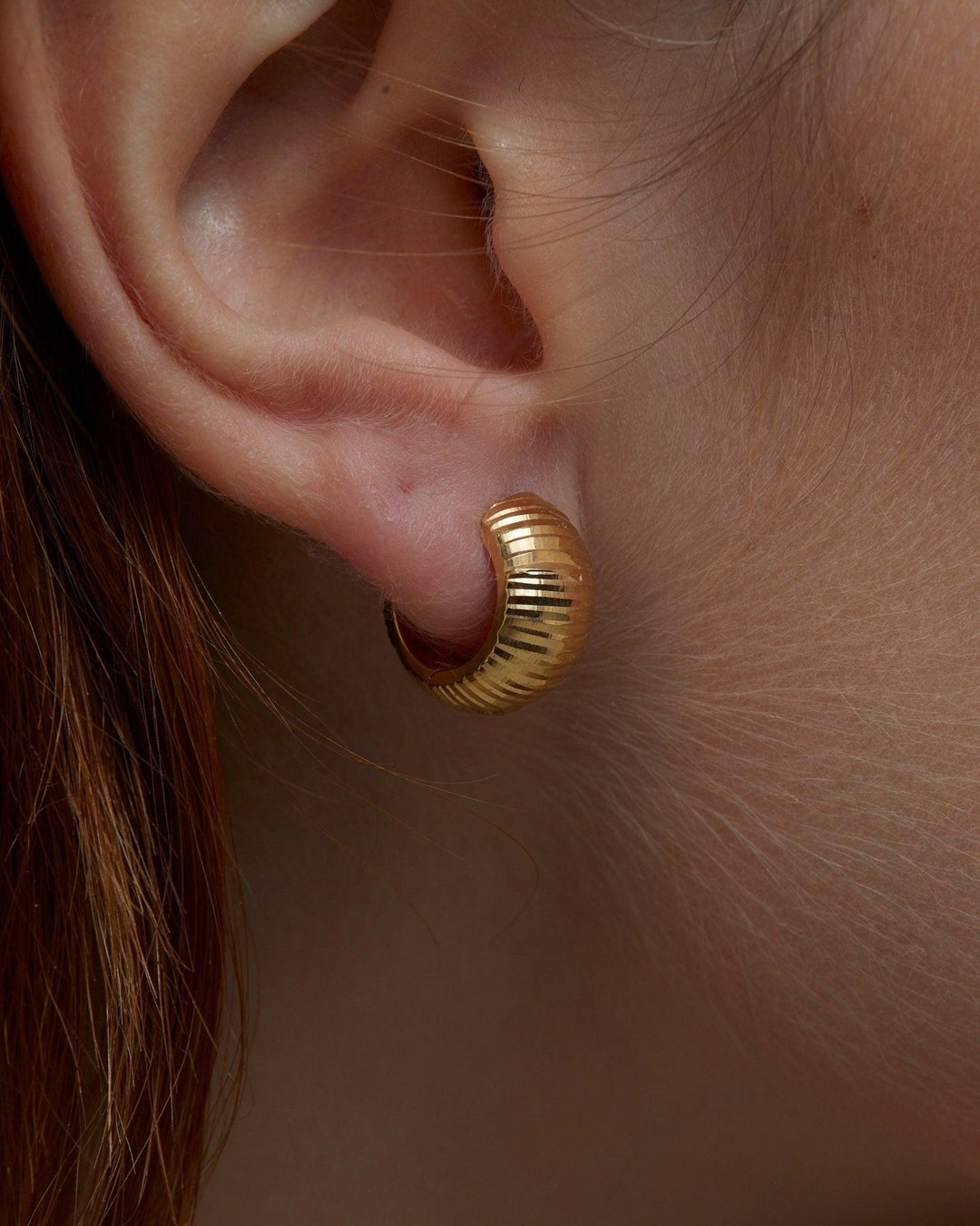 The Textured Huggie Earrings worn in 18K Gold Vermeil — refined accessory for women. Tarnish-resistant.