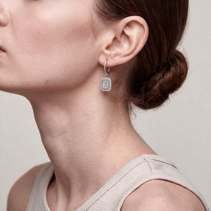 Model wearing the art deco baguette diamond drop earrings in 14K white gold with an oatmeal ribbed tank