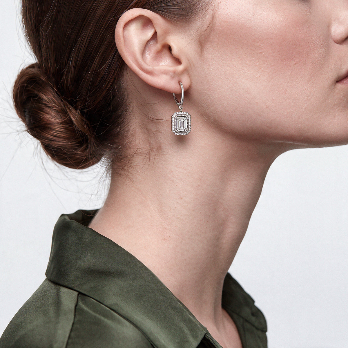 Model wearing the art deco baguette diamond drop earrings in 14K white gold with an olive-green silk blouse